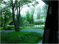 Looking out of the campervan door to the trout lake. You can just see their Large Black pig pens in the background..png