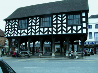 My parents outside The Market House, Ledbury (at right, looking after Ellie for me) enjoying their sausage rolls..png